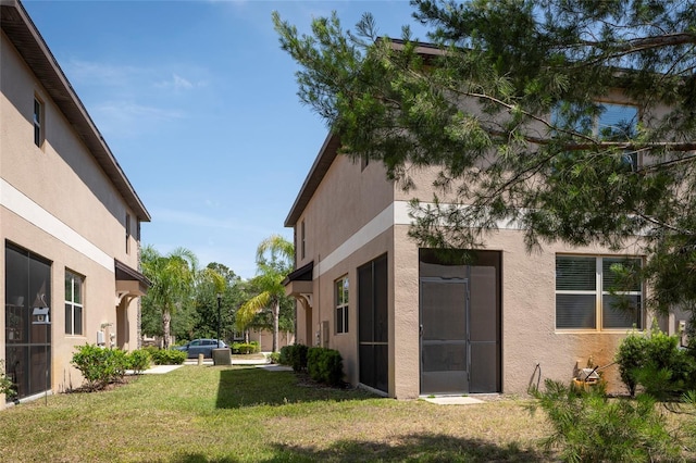 11704 Castine St, New Port Richey, FL 34654 - view of property exterior featuring a lawn and stucco siding