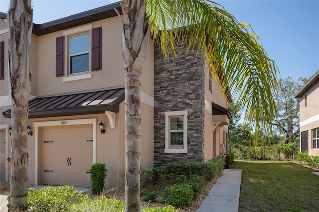 11704 Castine St, New Port Richey, FL 34654 - view of side of home with an attached garage, stone siding, a yard, stucco siding, and a standing seam roof