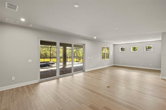spare room with visible vents, light wood-style flooring, baseboards, and recessed lighting