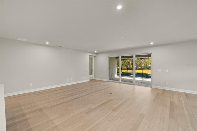 unfurnished room featuring baseboards, light wood finished floors, and recessed lighting