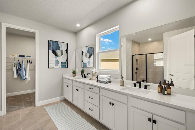 full bathroom with a walk in closet, a sink, double vanity, recessed lighting, and a stall shower