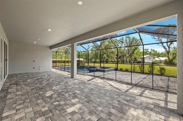 view of patio / terrace featuring a lanai and a pool with connected hot tub