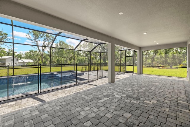 exterior space with glass enclosure and a pool with connected hot tub