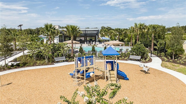 community jungle gym with a community pool and fence