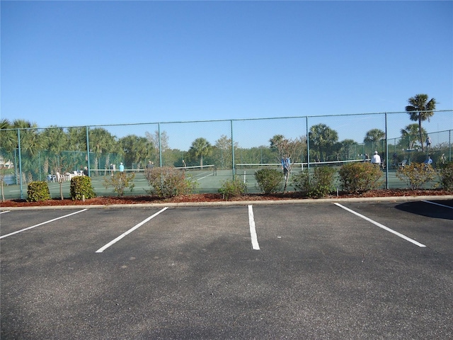 10034 64th Ave N Unit 21, Saint Petersburg, FL 33708 - uncovered parking lot with a tennis court and fence