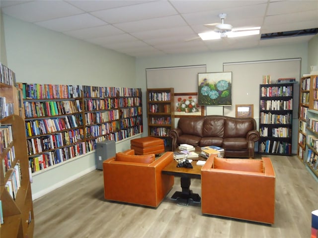 10034 64th Ave N Unit 21, Saint Petersburg, FL 33708 - sitting room featuring a drop ceiling, bookshelves, and wood finished floors
