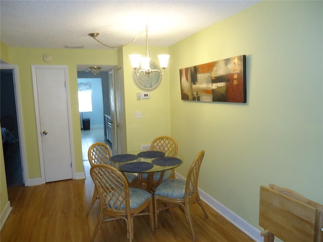 10034 64th Ave N Unit 21, Saint Petersburg, FL 33708 - dining area featuring wood finished floors, an inviting chandelier, and baseboards