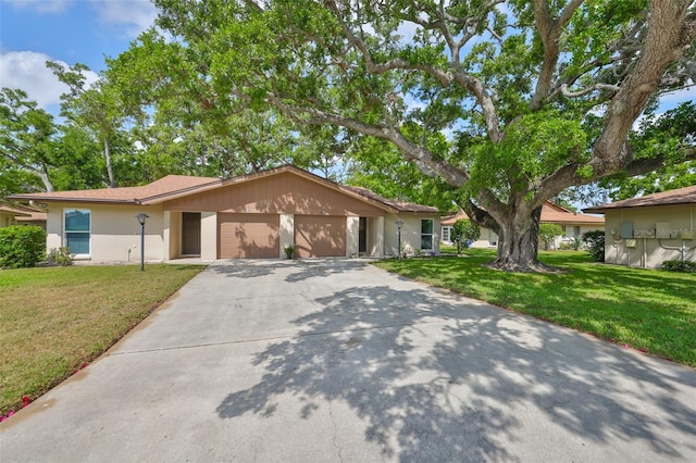 ranch-style house featuring a front lawn, stucco siding, a garage, and concrete driveway