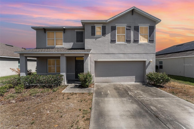 5597 Forest Ridge Dr, Winter Haven, FL 33881 - view of front of home with stucco siding, concrete driveway, an attached garage, and a porch