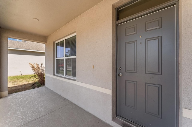 5597 Forest Ridge Dr, Winter Haven, FL 33881 - view of exterior entry featuring stucco siding and covered porch