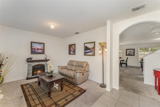 5597 Forest Ridge Dr, Winter Haven, FL 33881 - living area with light colored carpet, arched walkways, a fireplace, light tile patterned flooring, and baseboards