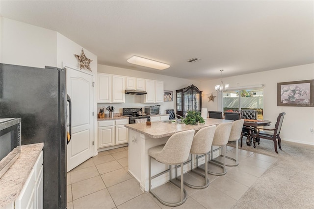 5597 Forest Ridge Dr, Winter Haven, FL 33881 - kitchen with electric range oven, freestanding refrigerator, light tile patterned floors, and a chandelier
