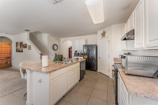 5597 Forest Ridge Dr, Winter Haven, FL 33881 - kitchen featuring under cabinet range hood, black appliances, a sink, and arched walkways