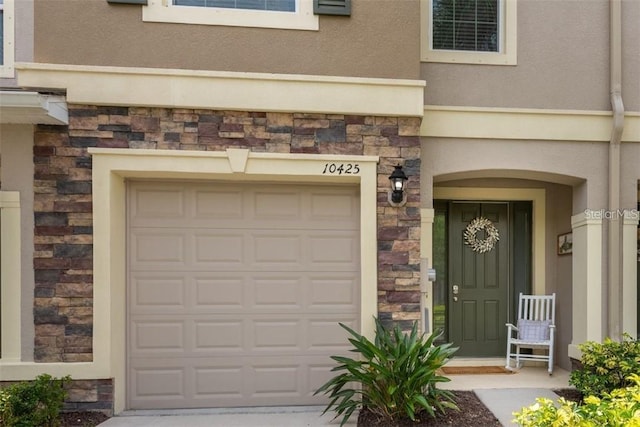 10425 Yellow Spice Ct, Riverview, FL 33578 - view of exterior entry featuring an attached garage, stucco siding, and stone siding