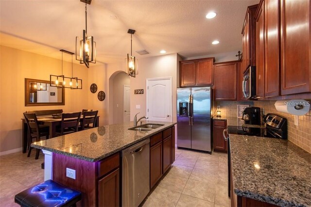 10425 Yellow Spice Ct, Riverview, FL 33578 - kitchen featuring tasteful backsplash, dark stone counters, stainless steel appliances, arched walkways, and a sink