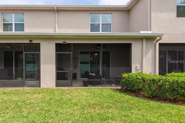 10425 Yellow Spice Ct, Riverview, FL 33578 - rear view of property with a sunroom, stucco siding, and a lawn