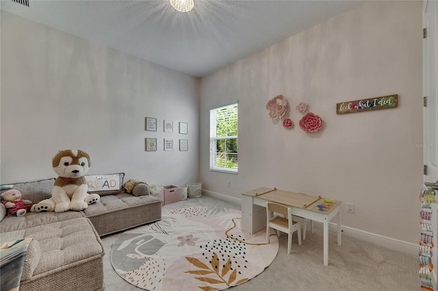 living area with baseboards, visible vents, and light carpet
