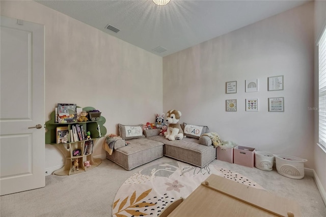 living room with carpet floors, visible vents, and a wealth of natural light