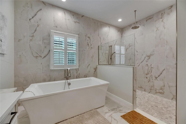 bathroom featuring marble finish floor, a freestanding tub, tile walls, recessed lighting, and a walk in shower