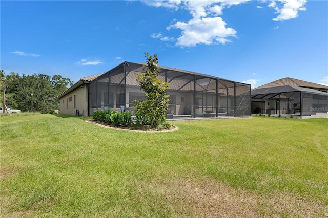 rear view of property featuring a lawn and a lanai