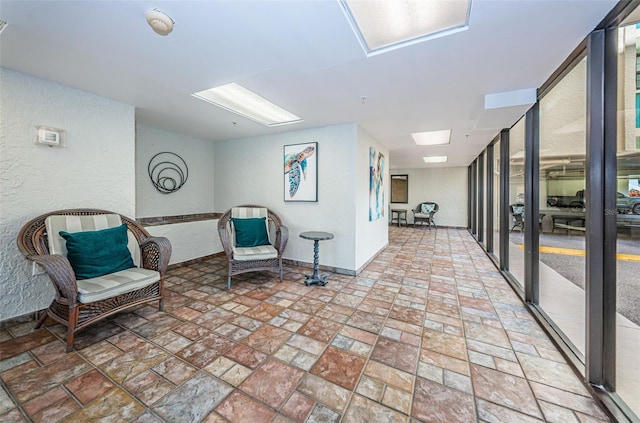 sitting room with a textured wall and stone finish flooring