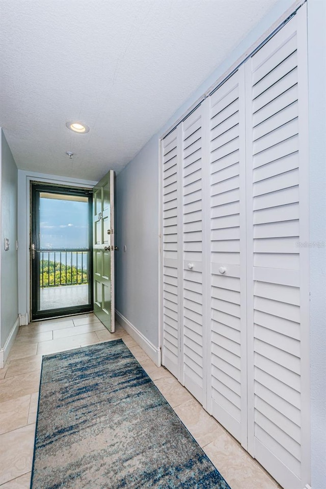 hall with recessed lighting and baseboards