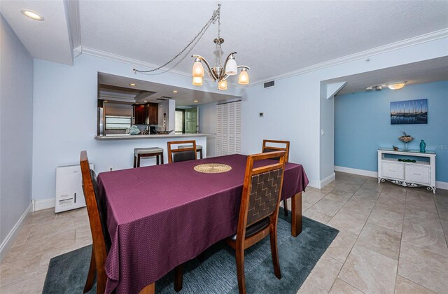 dining room featuring visible vents, baseboards, an inviting chandelier, and crown molding
