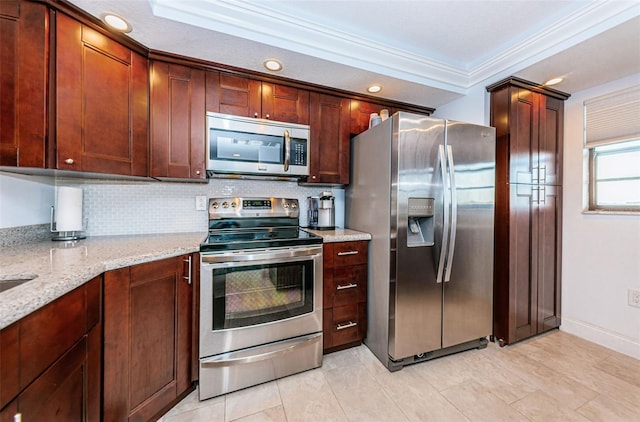 kitchen with crown molding, light stone counters, stainless steel appliances, decorative backsplash, and baseboards