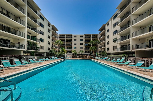 pool with a patio and fence