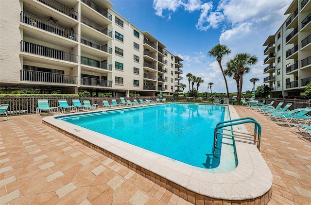pool with a patio area and fence