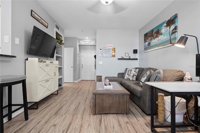 living area featuring light wood-type flooring, a ceiling fan, and visible vents