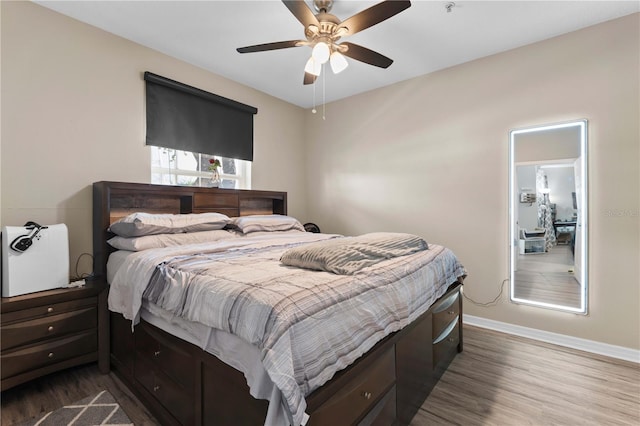 bedroom featuring baseboards, a ceiling fan, and dark wood-style floors