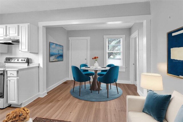 dining room with baseboards and light wood finished floors