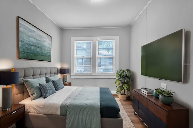 bedroom featuring light wood-style floors and crown molding