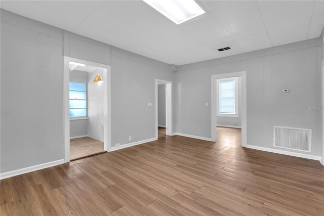 interior space with multiple windows, light wood-type flooring, and visible vents