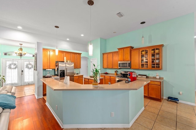 2539 Centennial Falcon Dr, Valrico, FL 33596 - kitchen featuring appliances with stainless steel finishes, a large island with sink, light countertops, glass insert cabinets, and recessed lighting