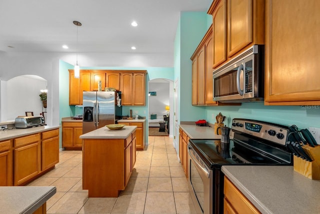 2539 Centennial Falcon Dr, Valrico, FL 33596 - kitchen featuring stainless steel appliances, arched walkways, a kitchen island, recessed lighting, and light tile patterned flooring