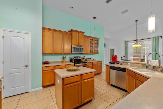 2539 Centennial Falcon Dr, Valrico, FL 33596 - kitchen with stainless steel appliances, light countertops, light tile patterned floors, and hanging light fixtures