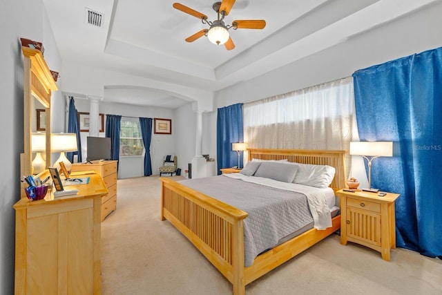 2539 Centennial Falcon Dr, Valrico, FL 33596 - bedroom featuring light colored carpet, arched walkways, decorative columns, a ceiling fan, and a tray ceiling