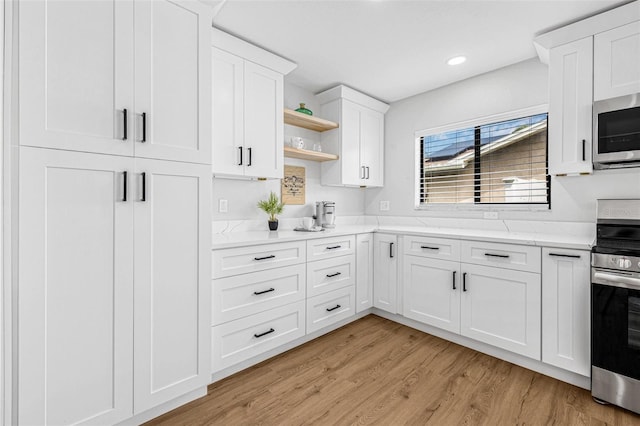 12641 98th St, Largo, FL 33773 - kitchen with recessed lighting, white cabinetry, open shelves, stainless steel appliances, and light wood finished floors