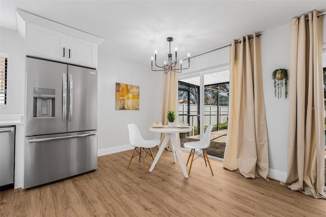 12641 98th St, Largo, FL 33773 - dining space featuring light wood-type flooring, a notable chandelier, and baseboards