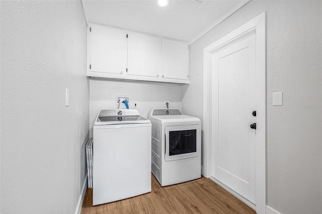 12641 98th St, Largo, FL 33773 - clothes washing area featuring cabinet space, washing machine and clothes dryer, light wood finished floors, and a textured wall