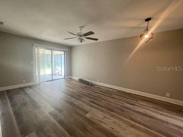 unfurnished room featuring ceiling fan, baseboards, dark wood-style floors, and visible vents