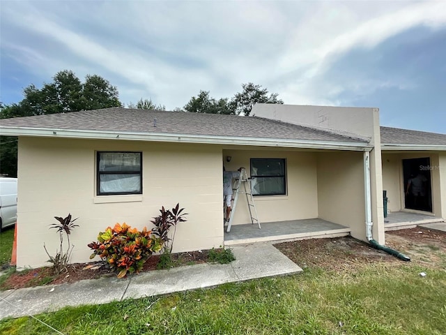 view of front of home with roof with shingles and concrete block siding