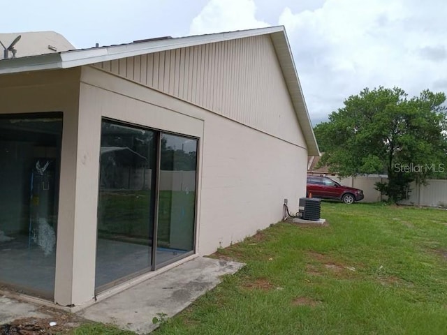 view of home's exterior featuring a yard, fence, and central AC unit