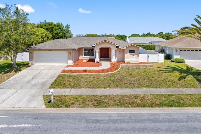 ranch-style house with concrete driveway, stucco siding, an attached garage, a front lawn, and a gate