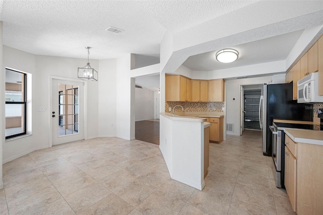 kitchen with tasteful backsplash, white microwave, electric stove, and light brown cabinets
