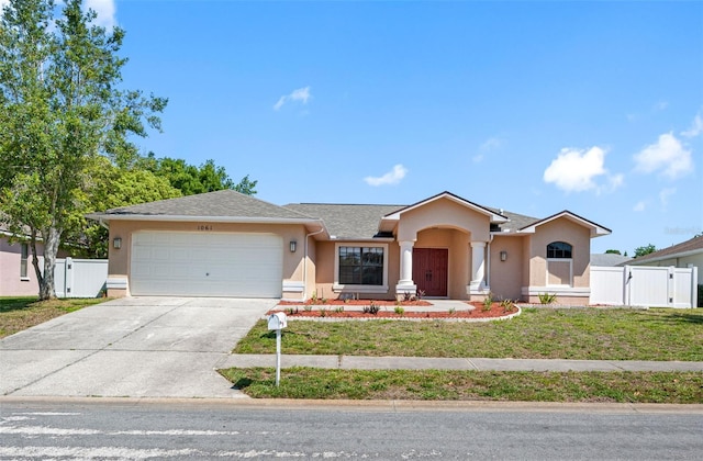 ranch-style home with a garage, fence, concrete driveway, stucco siding, and a gate