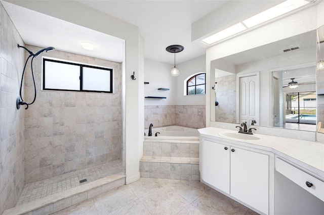bathroom with vanity, tile patterned floors, tiled shower, a bath, and visible vents
