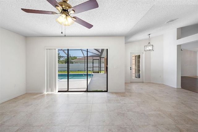 tiled empty room with ceiling fan, a sunroom, baseboards, and a textured ceiling